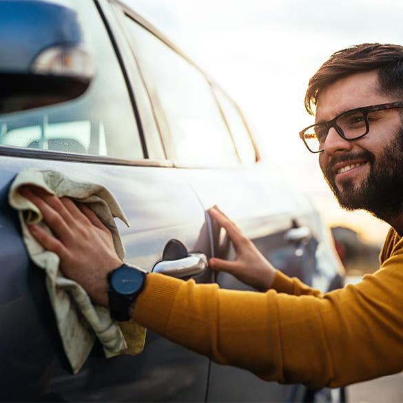Mann wäscht sein blaues Auto